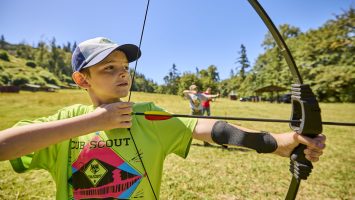 Cub Scouts at an archery range shooting bows and arrows